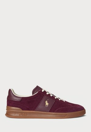Maroon suede and leather sneaker with white laces, beige logo emblem on side, brown sole embossed with "Polo," and padded collar interior.
