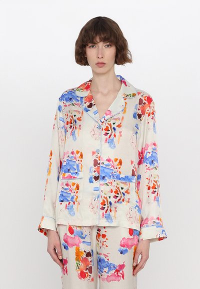 Pyjama set met bloemenpatroon in lichtgewicht stof; lange mouwen, reverskraag, twee zakken aan de voorkant; kleuren zijn roze, blauw en oranje op een crèmekleurige achtergrond.