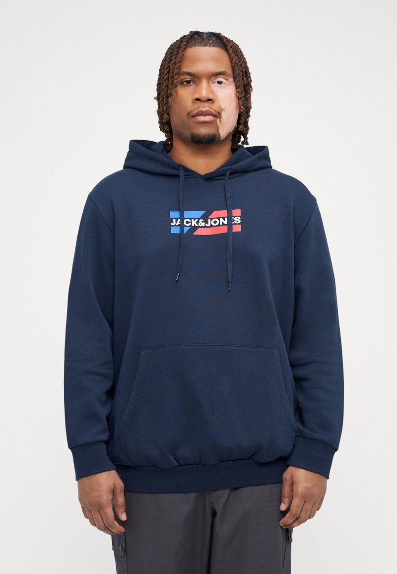 Marineblå hettegenser, myk stoff, frontlomme, snor i hetta, hvit og rød logo "JACK & JONES" på brystet, ribbestrikkede mansjetter og nederkant.