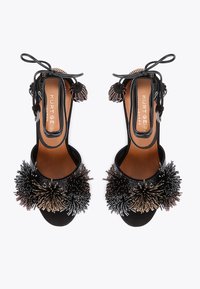 Czarne sandały na obcasie z odkrytymi palcami, ozdobione misternymi koralikowymi motywami kwiatowymi, z wiązaniami na kostkach i gładką skórzaną wkładką.