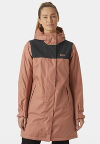 Abrigo resistente al agua con un cuerpo rosa y un panel superior negro, con capucha, bolsillos con cremallera y un logo en el pecho. Textura suave.