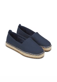 Espadrilles en toile marine avec semelle en corde de jute, bout arrondi, design slip-on, et détail de couture autour du bord de la semelle.