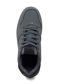 Temno siva superga z luknjicami na prstnem delu, debelimi vezalkami, oblazinjenim ovratnikom in majhnim logotipom krokodila na jezičku ter stranskih ploščah.