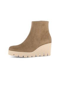 Botte à talon en wedge hauteur de cheville avec tige en daim beige et épaisse semelle en caoutchouc crème avec de profonds canaux pour une meilleure adhérence.