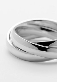 Drei ineinandergreifende Ringe aus poliertem Silbermetall. Die Ringe haben eine glatte, glänzende Oberfläche und zeichnen sich durch ein minimalistisches Design aus.