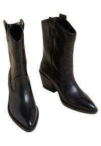 Czarne skórzane botki za kostkę z ostrym noskiem i słupkowym obcasem. Posiadają pętle do zakładania oraz dekoracyjne przeszycia po bokach.