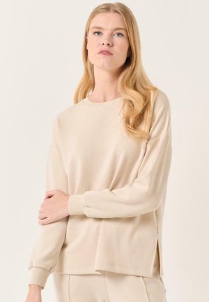 Beige sweatshirt met lange mouwen, geribde manchetten en zijsplitten, met een relaxte pasvorm en een gladde textuur. Eenvoudige ronde hals.