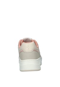 Sneaker con tomaia sintetica beige liscia, accentata da dettagli rosa, colletto imbottito e suola in gomma bianca testurizzata; presenta un dettaglio del logo sul tallone.