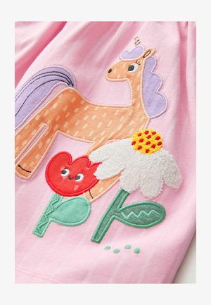 Un tessuto rosa presenta un unicorno ricamato con una criniera texturizzata, accanto a un fiore rosso con una faccia sorridente e una margherita bianca soffice.