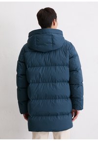 Doudoune couleur bleu sarcelle foncé, dotée d'une capuche, d'une texture matelassée et d'une coupe longue. Comprend des poches latérales et une finition lisse.