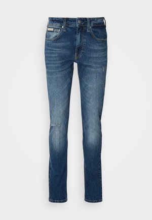 Modré džíny z denimu se rovný střihem, s vybledlým vzhledem, lehkým poškozením na koleni a klasickým pětic pocket designem.