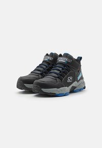 Schwarze wasserdichte Hochschnitt-Sneaker mit grauen Akzenten, blauen Schnürsenkeln und strukturierten Sohlen für besseren Halt. Mit gepolstertem Schaft und Branding.