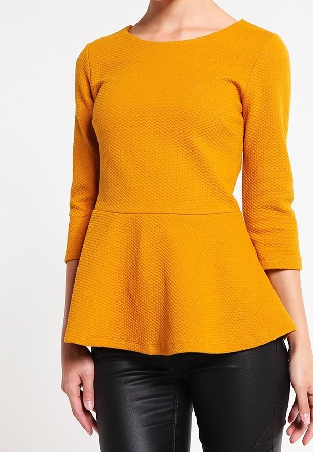 Mosterdgele peplumtop met driekwart mouwen, textuurstof en een aansluitende bustier die overgaat in een uitlopende zoom.