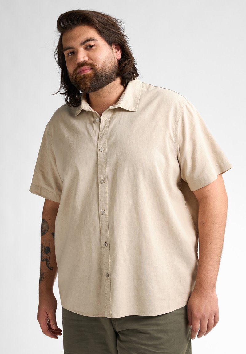 Beige short-sleeve overhemd met knoopsluiting en een puntige kraag, gemaakt van een gladde stof. Beschikt over zichtbare knopen en een relaxed fit. Casual ontwerp.