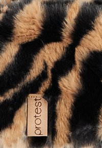 Bontaccessoire met een luipaardprint in bruin en zwart. Beschikt over een tan leren label met de tekst "protest".
