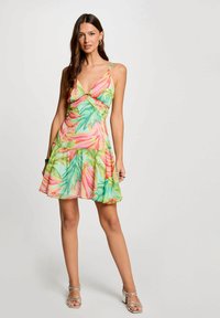 Abito floreale con profonda scollatura a V, spalline sottili e regolabili, e orlo arricciato. Motivo tropicale colorato in rosa, verde e giallo su tessuto leggero.