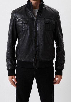 Zwarte leren bomberjack met ritssluiting, geribde manchetten en twee borstzakken; gladde textuur en een aansluitend ontwerp.