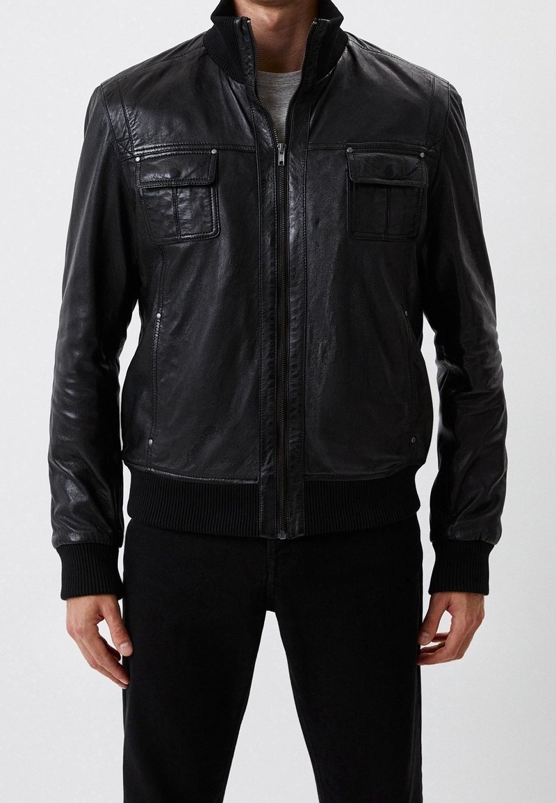 Czarna skórzana kurtka bomberka z zamkiem błyskawicznym, ściągaczami przy mankietach i dwiema kieszeniami na piersi; gładka tekstura i dopasowany krój.