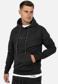 Felpa nera con cappuccio, dotata di cordini, tasca frontale, polsini e orlo a coste, con dettagli del logo in filo a contrasto sul petto e sulle maniche.