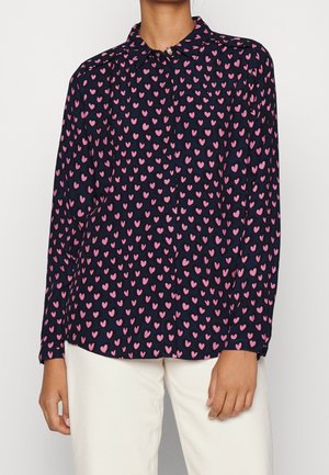 Langærmet skjorte i navy stof med et mønster af lyserøde hjerter. Har en klassisk krave og knaplukning foran.