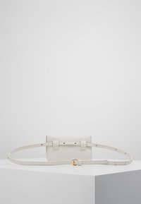 Biała skórzana torebka crossbody o teksturowanym wykończeniu, z regulowanym paskiem i złotymi akcentami. Posiada zapięcie na klapę z klamrą.