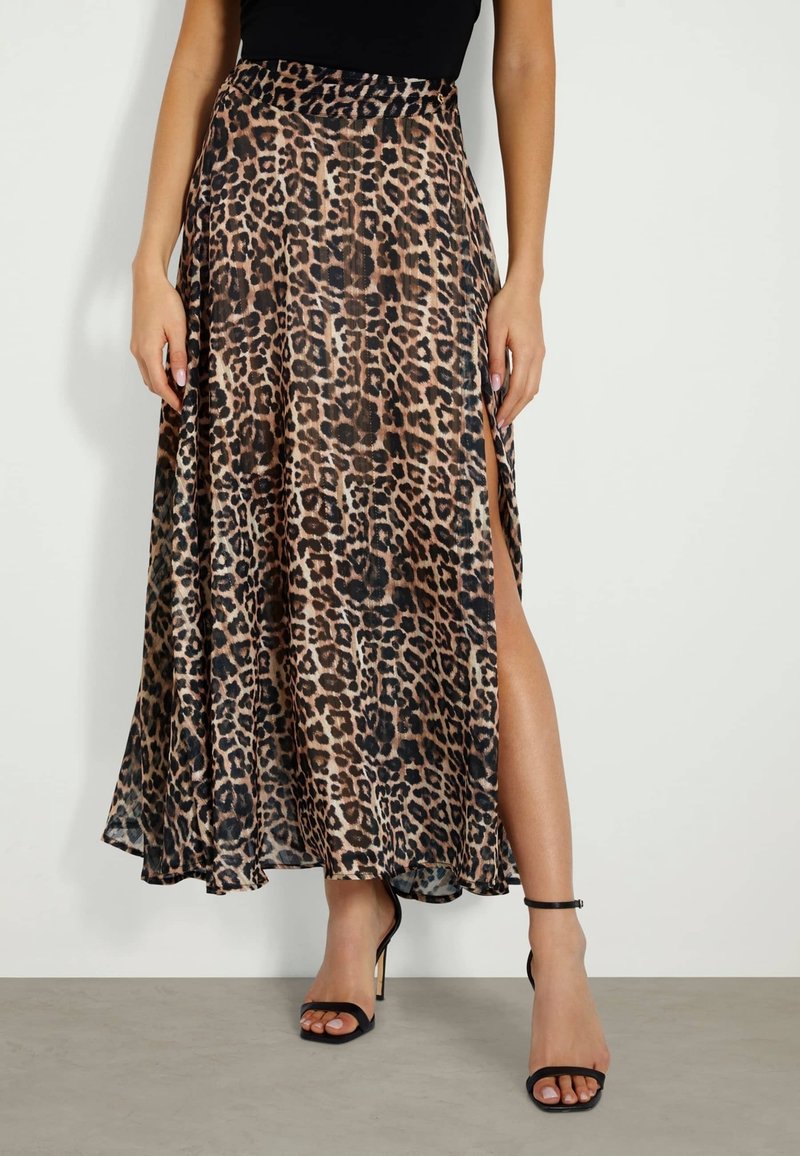Gonna maxi a stampa leopardata con uno spacco alto, realizzata in un tessuto fluido, con vita elastica e una texture liscia. Indossata con tacchi neri a strappo.