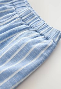 Lichtblauwe katoenen stof met witte verticale strepen, voorzien van een elastische tailleband en een gestructureerd oppervlak. Casual shorts ontwerp.