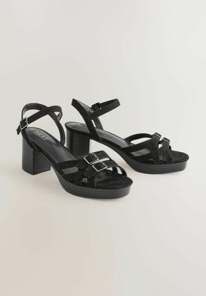 Sorte suede hælede sandaler med platform, der har to justerbare spænder, åben tå design og en struktureret block hæl.