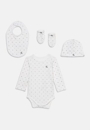 Valge beebiriiete komplekt, mis sisaldab pika varrukaga bodi, kindad, mütsi ja söögiriide, kõik väikeste mustade "CK" logodega ja klambritega.