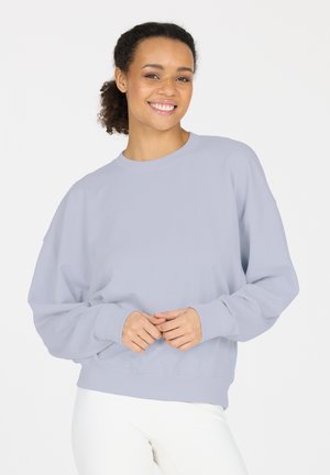 Hellblaues Sweatshirt mit rundem Ausschnitt, abgesenkten Schultern und gerippten Bündchen. Weiche Textur, lockere Passform und minimale Designmerkmale.