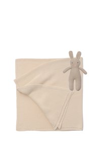 Beige gestrickte Decke mit einem gefalteten Rand und einem plüschigen beigefarbenen Kaninchen-Spielzeug, das daran befestigt ist. Die Stoffoberfläche ist glatt mit subtilen Rippungen.