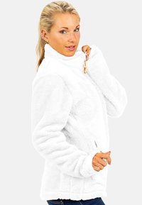 Witte fleece jack met hoge kraag, lange mouwen en ritsdetails. Heeft een zachte textuur en een nauwsluitende pasvorm, ideaal voor het laagjes dragen.