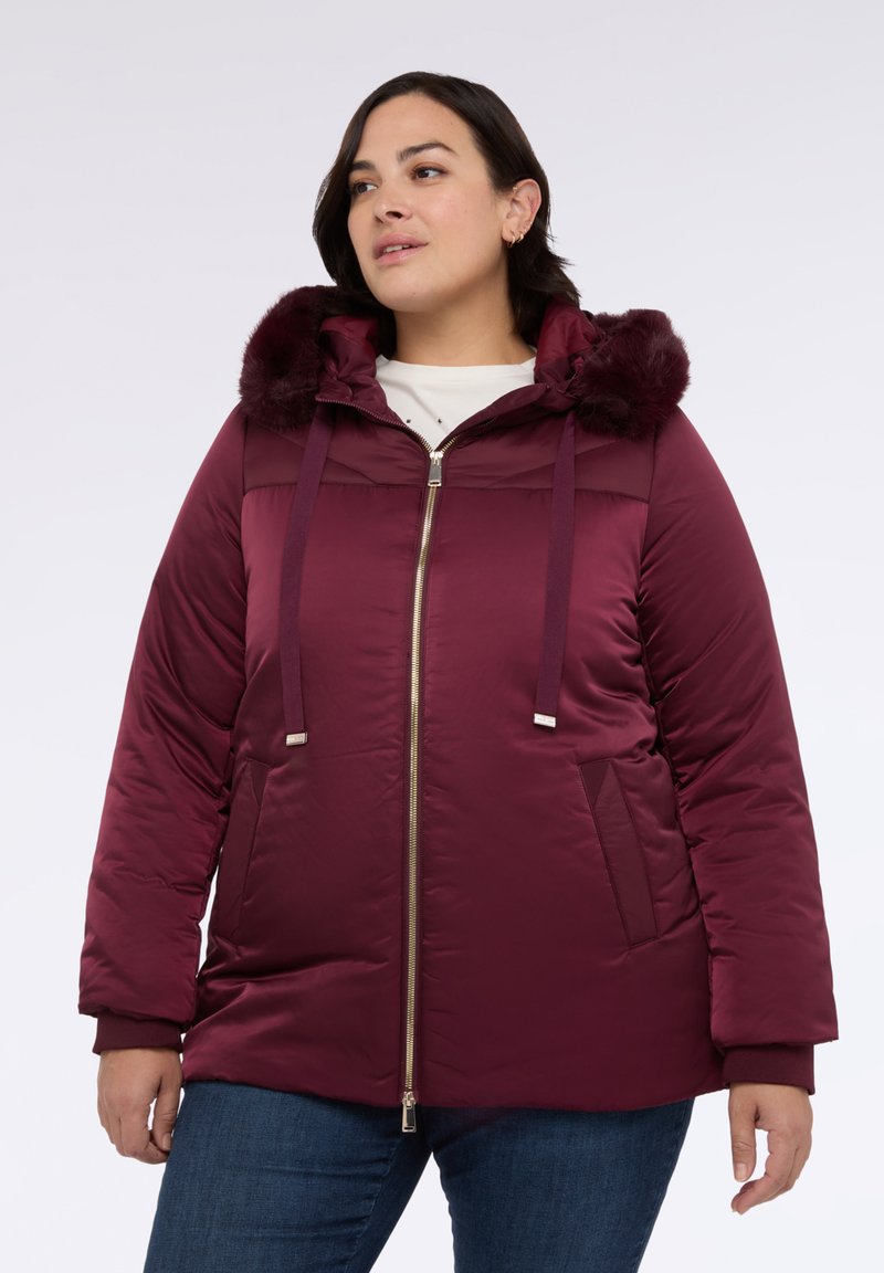 Burgundowa puchowa kurtka z kapturem wykończonym sztucznym futrem, z zapięciem na zamek, dwoma bocznymi kieszeniami i ściągaczami przy mankietach. Gładka, lekka tekstura.