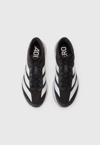 Black athletic shoes with a textured upper, featuring white diagonal stripes, lace closure, and a cushioned sole for support.