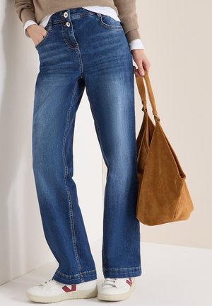 Jeans a gamba larga in denim blu medio dalla trama liscia, con due bottoni, tasche frontali e orlo pulito. Abbinati a una borsa in camoscio marrone.