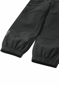Pantaloni impermeabili neri con polsini elasticizzati, dal design elegante e dalla texture liscia, dotati di due tasche laterali funzionali e dettagli riflettenti.