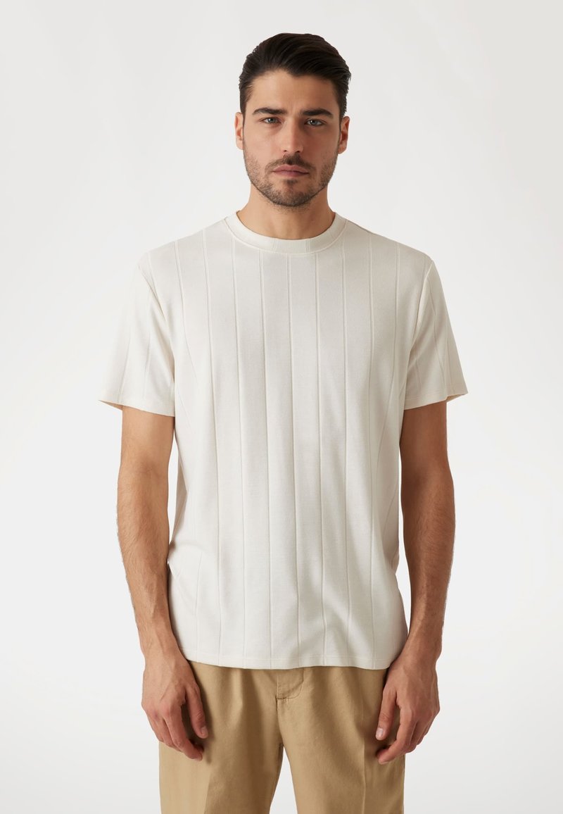 Kurzarm-T-Shirt mit Rundhalsausschnitt in Off-White mit senkrellem Rippstruktur. Weicher Stoff, taillierte Passform und saubere Verarbeitungsdetails.