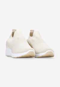 Baskets slip-on en tricot beige avec un dessus texturé, un col élastiqué et une semelle en caoutchouc blanche ; présente un léger design compensé.