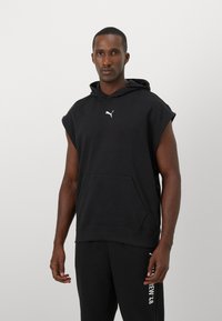 Zwarte mouwloze hoodie van een katoenmix, met een kenguruzak en het witte Puma-logo op de borst. Soepele textuur, relaxte pasvorm.