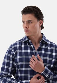 Camicia a maniche lunghe in cotone a quadri blu navy, con check bianchi e grigi, colletto con bottoni e polsini regolabili.