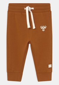 Bruna sweatsbyxor i mjukt material med elastisk midja, vit dragsko och en liten bi-design på vänster ben.