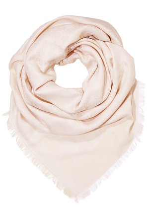 Foulard carré beige clair avec des motifs embossés subtils et des bords frangés, délicatement plié en forme circulaire sur un fond blanc.