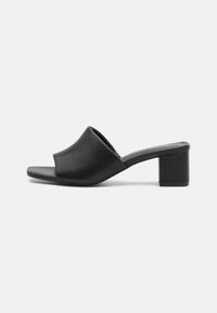 Black leather block-heeled mules with an open toe, featuring a smooth surface and slightly curved upper for comfort and style.