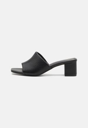 Black leather block-heeled mules with an open toe, featuring a smooth surface and slightly curved upper for comfort and style.