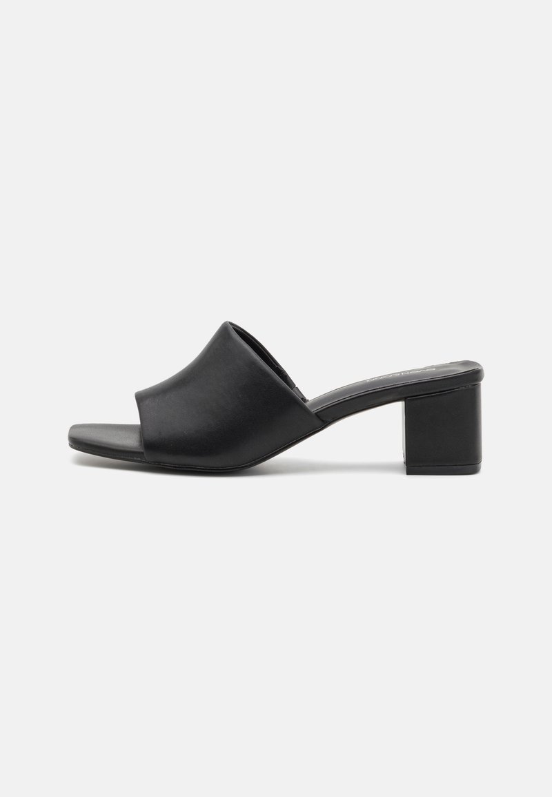 Black leather block-heeled mules with an open toe, featuring a smooth surface and slightly curved upper for comfort and style.