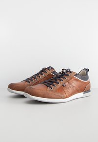 Brown leather sneakers with suede accents, featuring a rubber sole, navy laces, and a textured mesh panel at the heel.