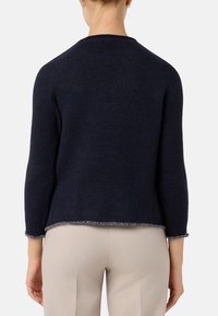 Maglione lavorato a maglia blu navy con maniche a tre quarti, scollatura rotonda e una finitura testurizzata in argento all'orlo. Tessuto morbido.