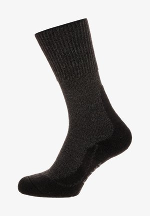 Calcetines negros con relieve, hechos de una tela texturada. Largo hasta la mitad de la pantorrilla, con puntera y talón reforzados, presentando un acabado suave.