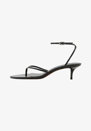 Sandalia negra con tiras, hebilla fina en el tobillo, lazo para el dedo y tacón bajo y delgado tipo kitten sobre fondo blanco.