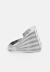 Anel de prata com um design elegante e curvado, acompanhado de camadas decorativas. A superfície texturizada adiciona profundidade e interesse visual.